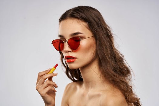 Fashionable brunette in sunglasses with makeup lipstick model. High quality photo