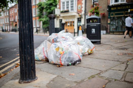 Picture of Plastic Bags of Trash Abandoned on the Sidewalk Next to a Lamppost in a street from London, UK