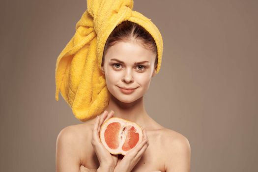 Woman with grapefruit in her hand clean skin bare shoulders spa health treatments. High quality photo