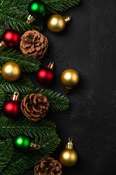 Christmas composition. Colorful ornament, pine cones and fir needles decorations on dark background. Top view copy space