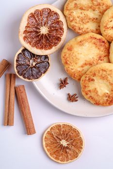 Cottage cheese fritters. Christmas breakfast mood with anise and cinnamon on white background, top view