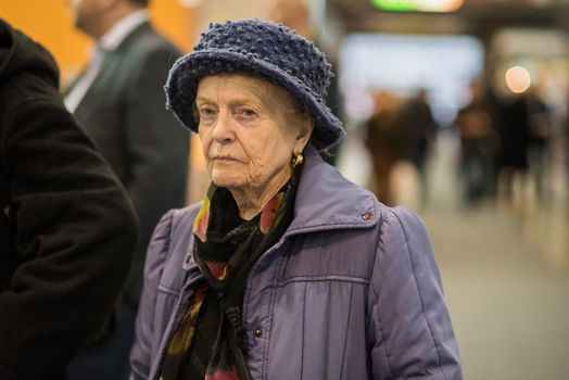 Old woman walking at a convention in Brno Exhibition Center (BVV trade fairs brno)