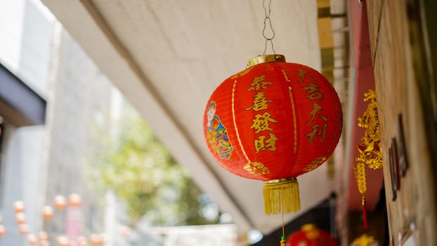 Photo of traditional red chinese Lamp hanging outside a biulding says 'Return to China' in chinese lettering.