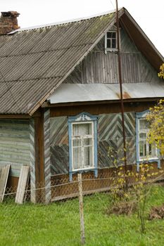 Old traditional wooden house with slate roof in village, Belarus. Vertical image