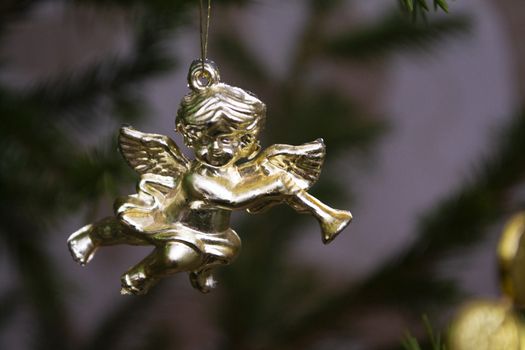 Christmas card with golden angel playing on a mandolin on a Christmas tree. Christmas card with blured background
