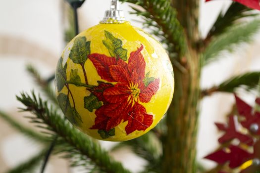 Christmas tree in ecorations. New Year composition with spruce. Red christmas flower Poinsettia on joy close up