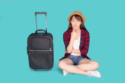 Beautiful portrait young asian woman thinking idea travel in vacation with luggage isolated on blue background, asia girl journey expression with cheerful and happy, holiday in summer concept.