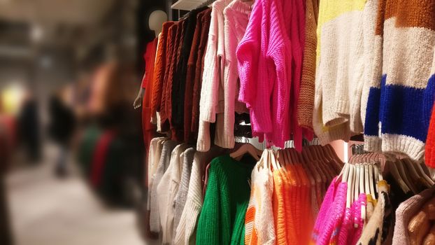 Sweaters on a hanger in a store - blurred background for text