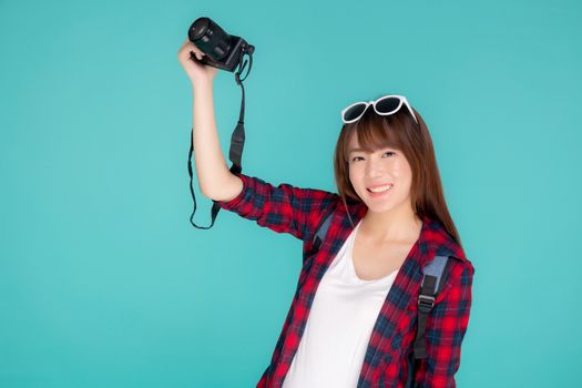 Beautiful young asian woman cheerful and enjoy travel trip summer isolated on blue background, asia girl having activity hobby take a photo holding camera, tourist journey in vacation and holiday.