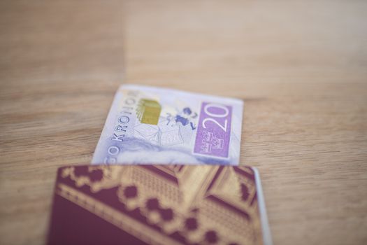 Picture of a 20 Swedish Kronor Banknote Partially inside a blurry Sweden Passport