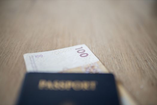 Picture of a 100 Moroccan Dirhams Bill Partially Inside a blurry United States of America Passport