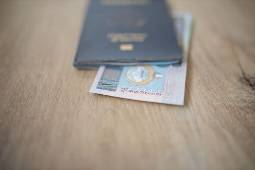 Picture of a One Kuwaiti Dinar Bill -with the number 1 in Arabic- Partially Inside a United States of America Passport