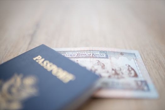 Picture of a Kuwait Quarter Dinar Partially Inside a blurry United States of America Passport