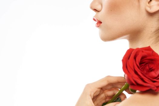 Beautiful woman with red rose near face makeup naked shoulders portrait. High quality photo