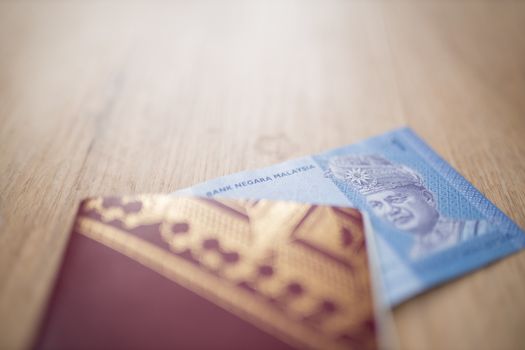 Picture of a One Malaysian Ringgit Note Inside a Sweden Passport, showing the face of Abdul Rahman