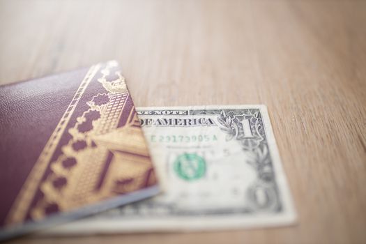 Half a One-Dollar Bill Under a Sweden Passport on a Wooden Table