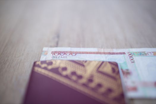 Picture of a Blurry Swedish Passport with half a 10.000 Colombian Pesos Bill Inside