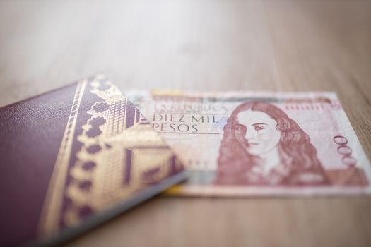 Picture of a Swedish Passport with half a 10.000 Colombian Pesos Bill Inside, showing the Face of Policarpa Salavarrieta