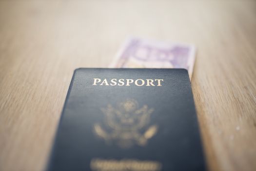 United States of America Passport with a Blurry Two Honduran Lempiras Bill under it, and both on a wooden table