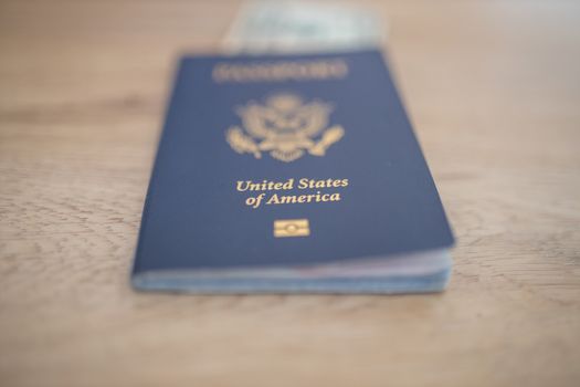 Picture of a blurry One-Dollar Bill Partially inside a United States of America Passport