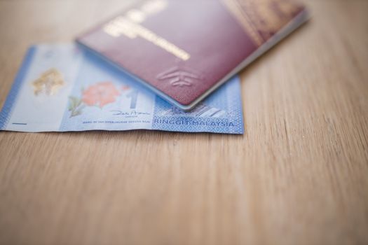 Picture of a Sweden Passport covering part of a blurry One Malaysian Ringgit Note