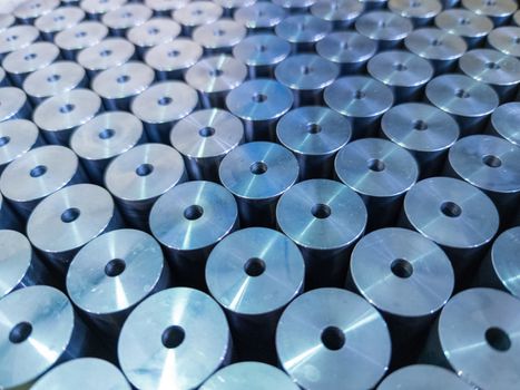 abstract background of shiny steel cylinder parts with central hole - laid tight in diagonal array