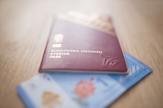 Picture of an European Union Sweden Passport covering part of a blurry One Malaysian Ringgit Note