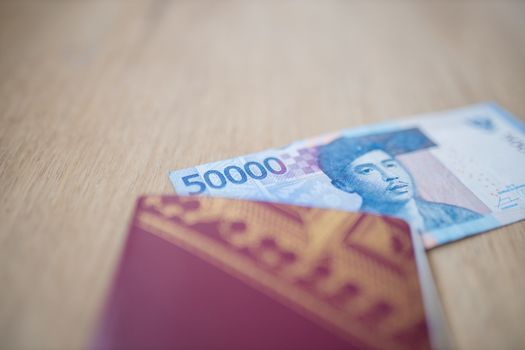 Picture of the corner of a Fifty Thousand Indonesian Rupees Bill partially inside a Swedish Passport