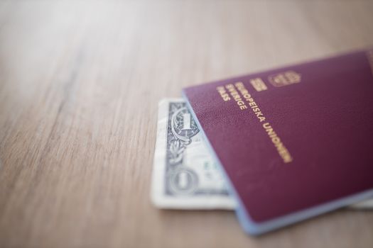 European Union, Sweden Passport with a One-Dollar Bill Partially Covered by it
