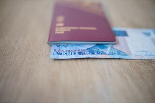 Picture of a Fifty Thousand Indonesian Rupees Bill partially inside a Swedish Passport