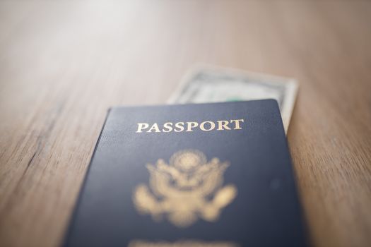 Picture of a blurry One-Dollar Bill Partially inside a United States of America Passport