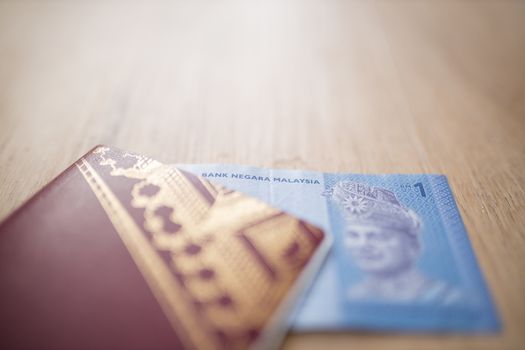 Picture of a One Malaysian Ringgit Note Inside a Sweden Passport, showing the face of the king Abdul Rahman