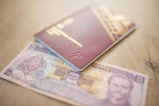 Picture of a Swedish Passport with a Two Honduran Lempiras Bill partially inside it, showing the face of Marco Aurelio Soto