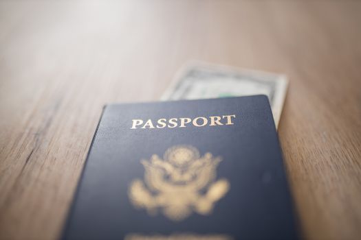 Picture of a blurry One-Dollar Bill Partially inside a United States of America Passport