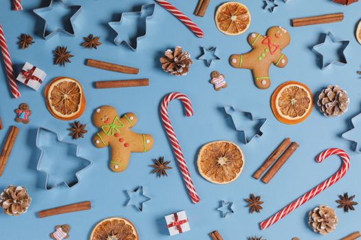 Christmas food frame. Gingerbread cookies, spices and decorations on blue background with copy space