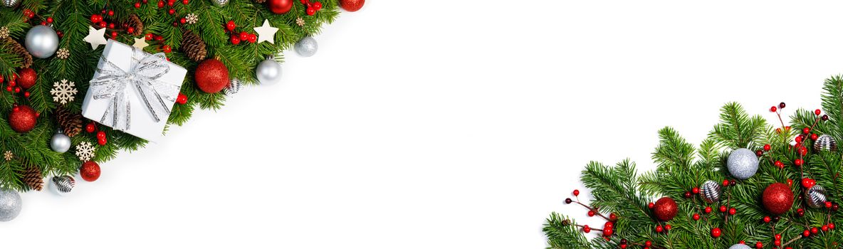 Christmas corner Border frame of tree branches isolated on white background with copy space , red and silver decor, berries, stars, cones, gift box