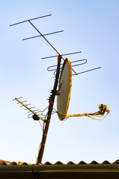 Different antennas on the roof of the house.