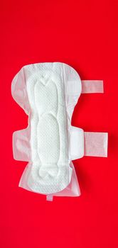Feminine sanitary pads for menstrual protection are placed on a red background.