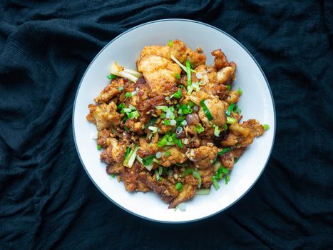 Thai food Stir fry chicken and chili in oil. Local Thai food can be eaten in a restaurant. The main ingredient uses fried chicken with chili on, black background.