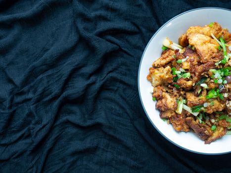 Thai food Stir fry chicken and chili in oil. Local Thai food can be eaten in a restaurant. The main ingredient uses fried chicken with chili on, black background.