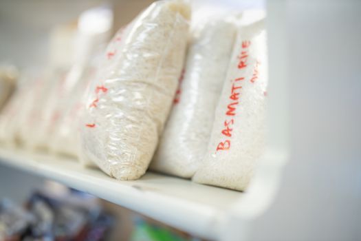 Picture of Basmati Rice Packed in Plastic Bags and on a Shelf Ready for Sale with prices written on the bags