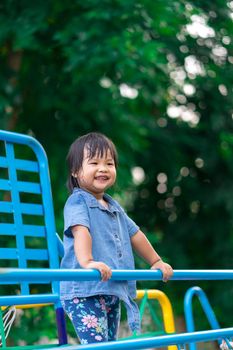 Asian little girl enjoys playing in a children playground