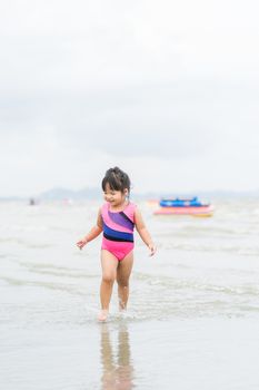 happy little girl running on the beach