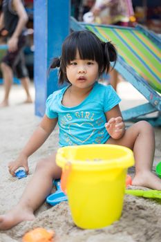 little girl playing sand on the beach