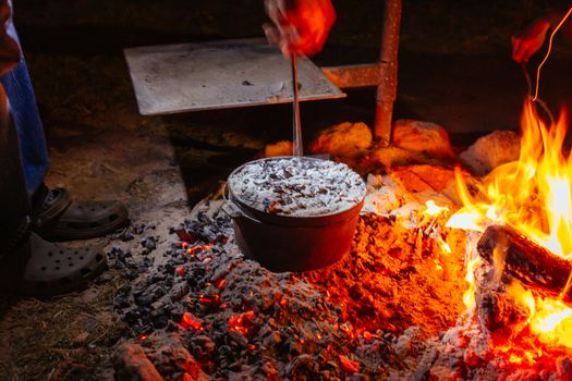 A pot with damper being heated in a bonfire in Northern Territory, Australia