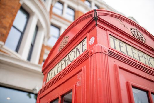 Landscape Close up view of the top of a classic London telephone booth with a blurry brick building as background