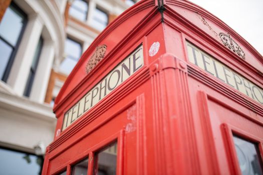 Landscape Close up view of the top of a classic London telephone booth with a blurry brick building as background