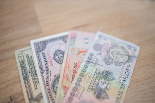 Picture of a Twenty-Dollar, Five Sucres -with Central of Ecuador in Spanish-,Ten Quetzales -with Ten in Spanish-, and Five Lempiras Bills -with Republic of Honduras Central Bank and Five in Spanish-