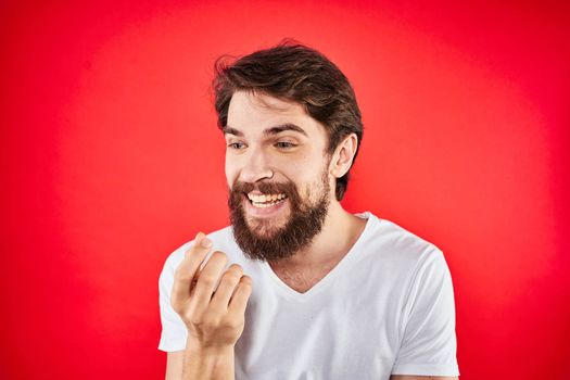 Bearded man fun emotions lifestyle cropped view white t-shirt red background. High quality photo