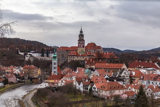 Aerial panorama view of Český Krumlov old town with the Cesky Krumlov castle and tower in background and Vltava river flowing around on a cloudy day, Czech Republic